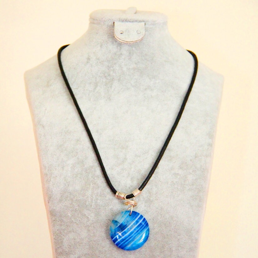 Blue striped round pendant on a black cord