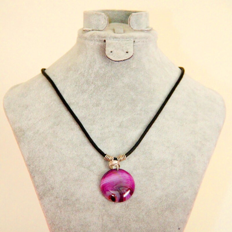 Pink and purple pendant on a black cord