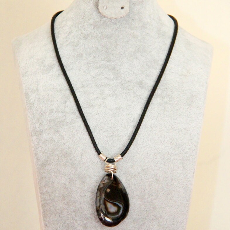 Dark oval pendant on a black cord